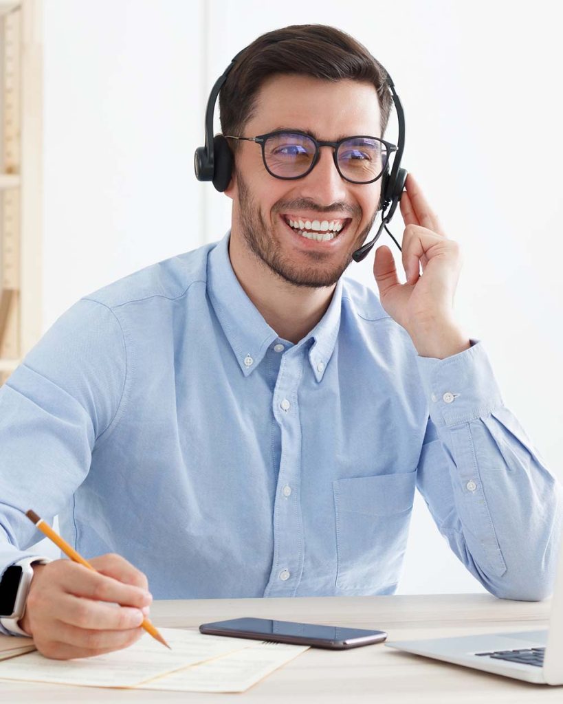 Smiling customer service worker sitting with lapt KSKUBDF.jpg